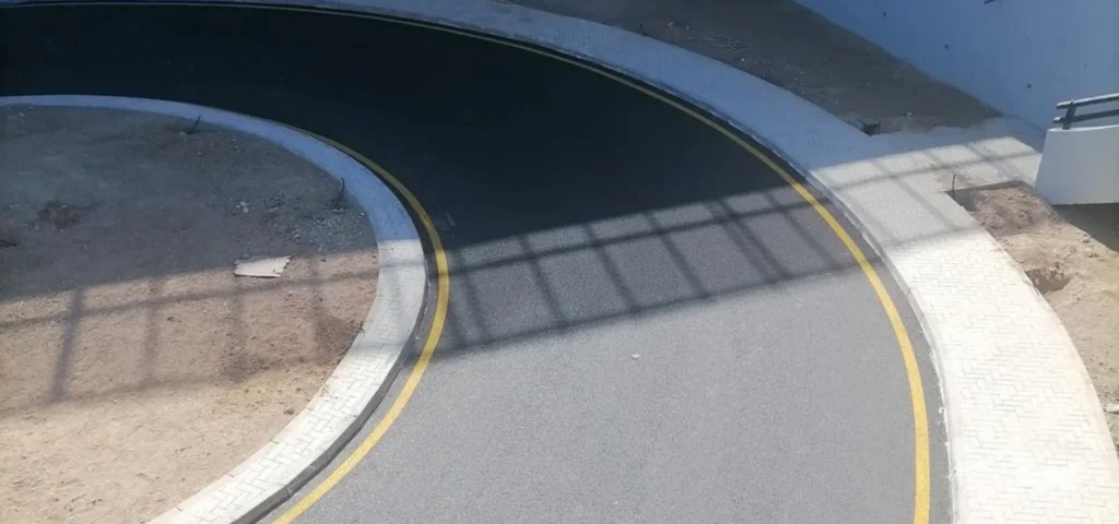 Virajlı asfalt yolda uygulanan sarı sürekli yol kenar çizgileri