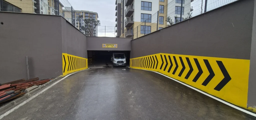 Otopark giriş rampası duvarlarında sarı siyah çavuş tarama ve beyaz kenar çizgileri