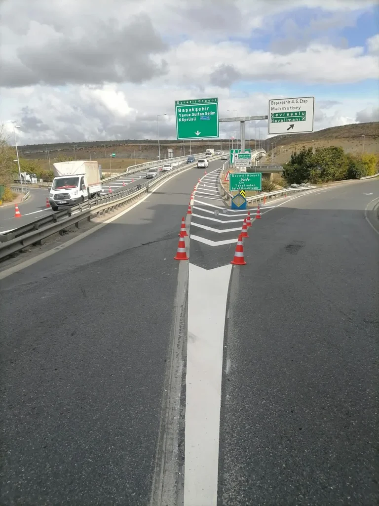 Otoyol kavşağında yol ayrımını belirleyen beyaz ofset tarama çizgileri ve yönlendirme kaması