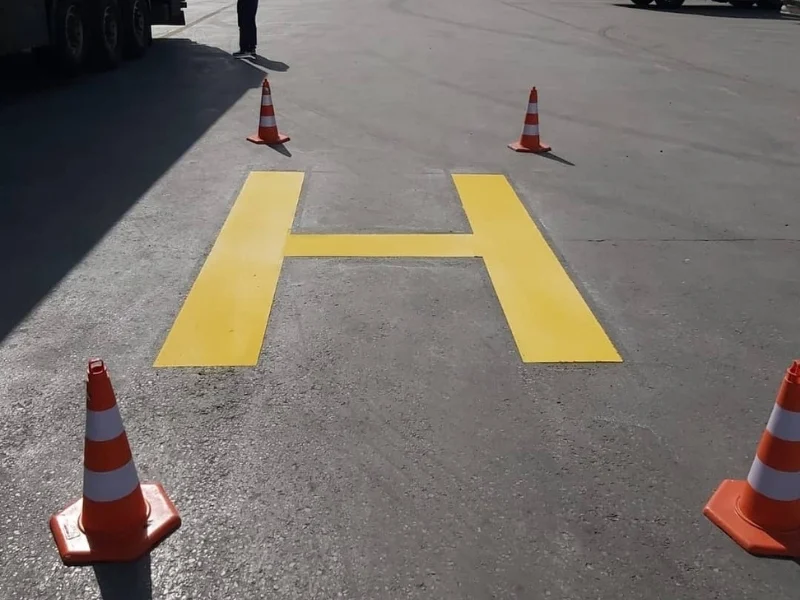 Asfalt zemine sarı boya ile uygulanan helikopter pisti H işareti