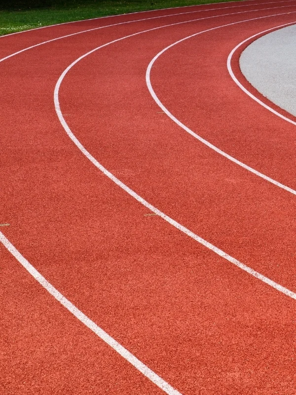 Kırmızı atletizm pistinin viraj bölümüne uygulanan beyaz kulvar sınır çizgileri