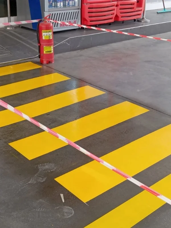 Benzinlik market girişinde uygulanan sarı yaya geçidi çizgileri