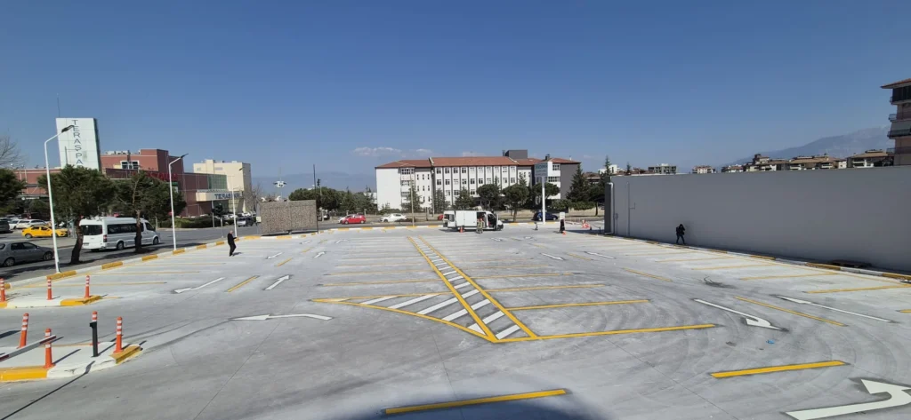 Otoparkta çift kompenantlı boya ile yapılan park çizgileri, yön okları ve taralı alanlar