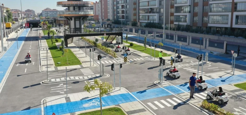 Çocuk trafik eğitim pistinde yol çizgileri, yaya geçitleri, yön okları, bisiklet yolları ve trafik işaretleri
