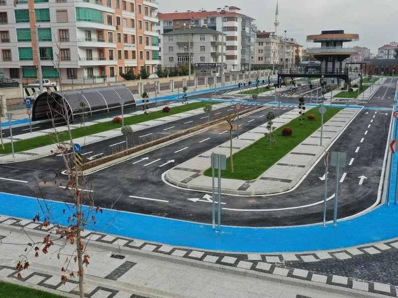 Çocuk trafik parkındaki beyaz şeritler, yön okları, kavşaklar ve mavi bisiklet yolu