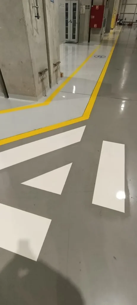 Epoksi boya üzerine uygulanan beyaz yön oku, geçiş şeritleri ve sarı koridor sınır çizgileri