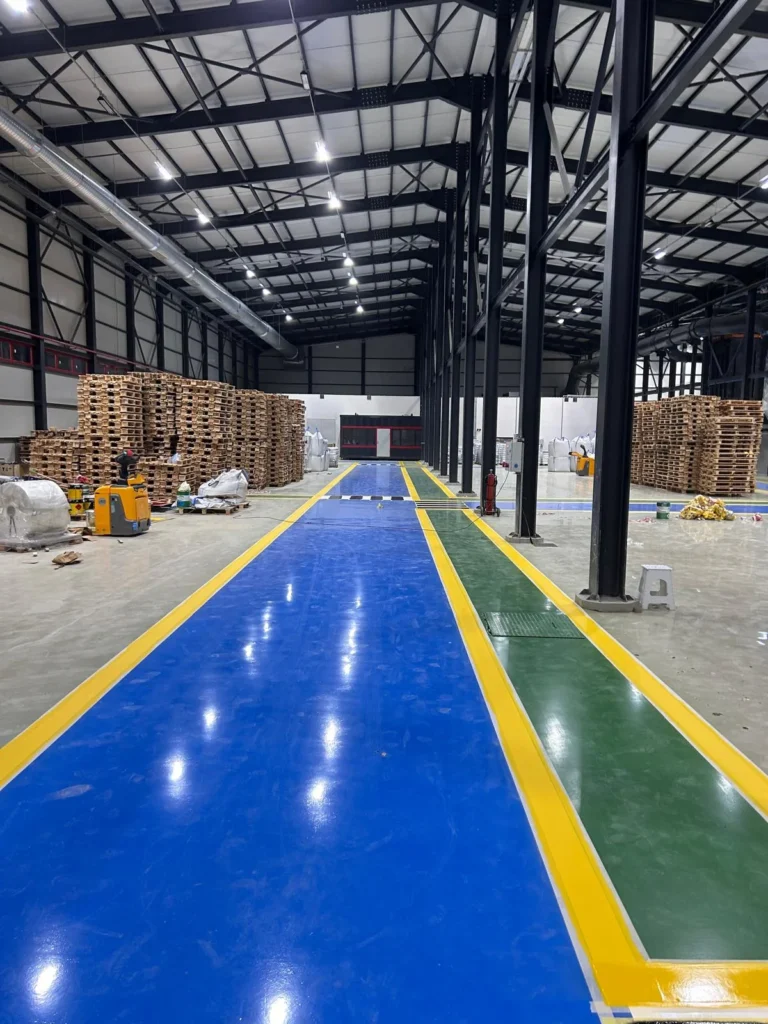 Fabrika içinde mavi lojistik yolu, yeşil geçiş bölümü ve sarı sınır çizgileri