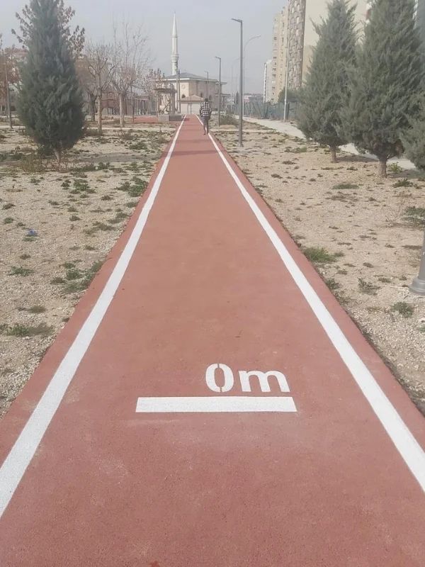 Kırmızı koşu yolunda beyaz kenar çizgileri ve sıfır metre başlangıç işareti