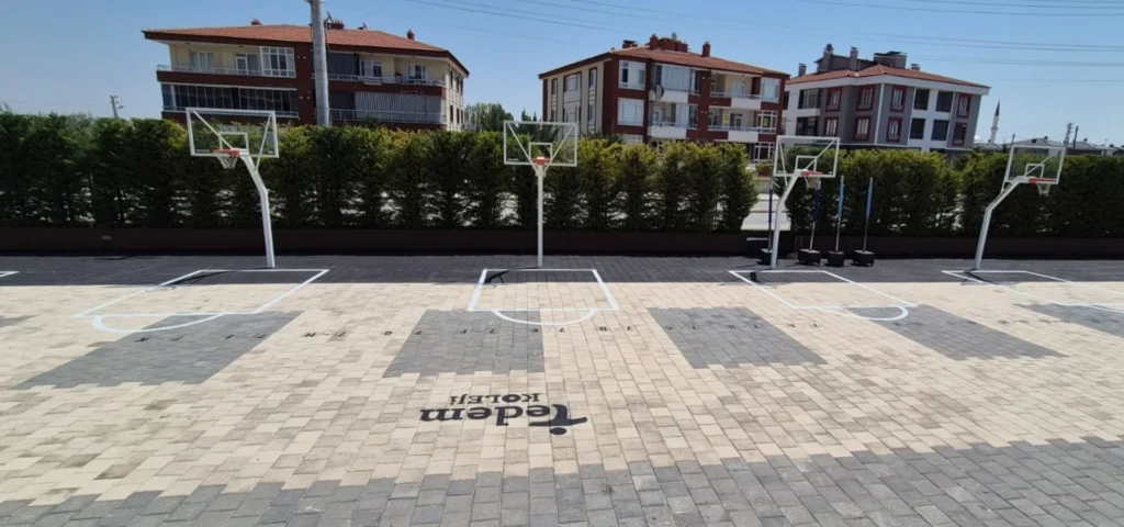 Okul bahçesindeki basketbol oyun alanlarına uygulanan beyaz saha çizgileri