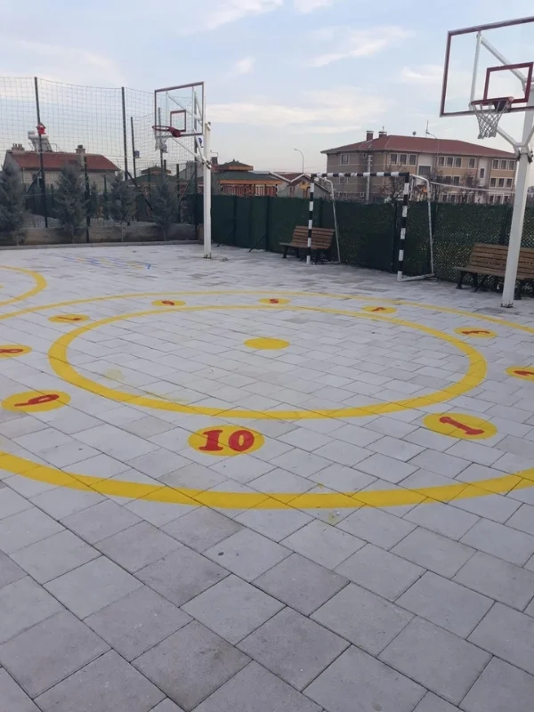 Basketbol sahasında sarı çemberler ve kırmızı rakamlarla oluşturulan çocuk oyun parkuru
