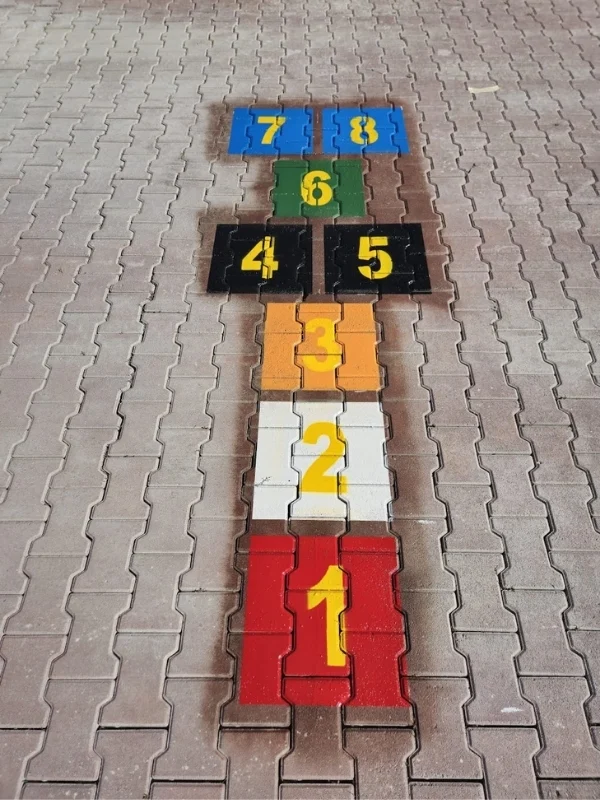 Okul bahçesi kilitli taş zeminine birden sekize kadar rakamlarla boyanan renkli seksek