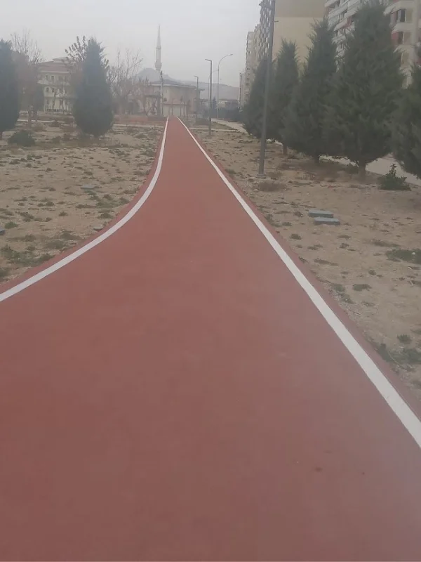 Park içerisindeki kırmızı koşu yoluna uygulanan beyaz kenar sınır çizgileri
