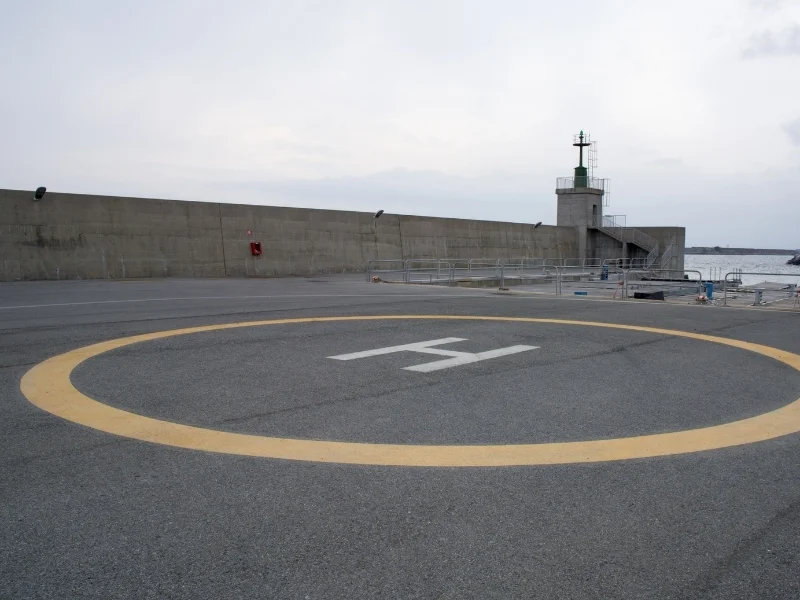 Sahil bölgesindeki helikopter pistinde sarı dairesel sınır çizgisi ve beyaz H işareti