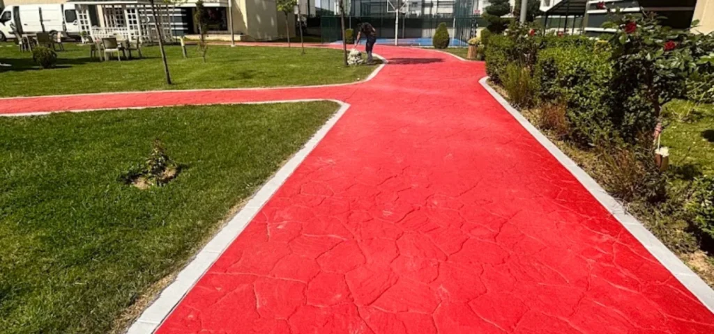 Site içerisindeki peyzaj alanında kırmızı zemin boyasıyla belirlenen yürüyüş ve yaya yolu